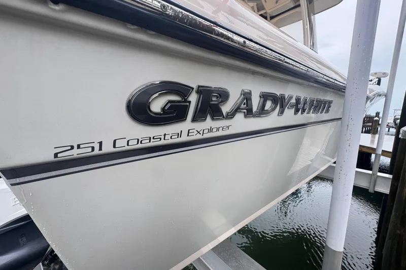Slide: The Image of 2022 Grady-White 251 Coastal Explorer boat docked, showcasing sleek design and branding. - 8