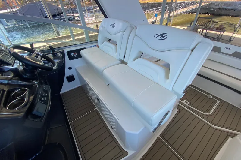 Slide: The Image of 2017 Monterey 355 Sport Yacht interior with white seating and steering wheel. - 11