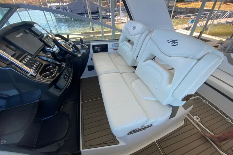 Slide: The Image of 2017 Monterey 355 Sport Yacht helm with dual white seats and modern controls. - 12