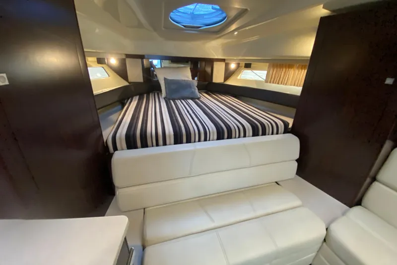 Slide: The Image of 2017 Monterey 355 Sport Yacht interior with striped bedding and modern furnishings. - 31