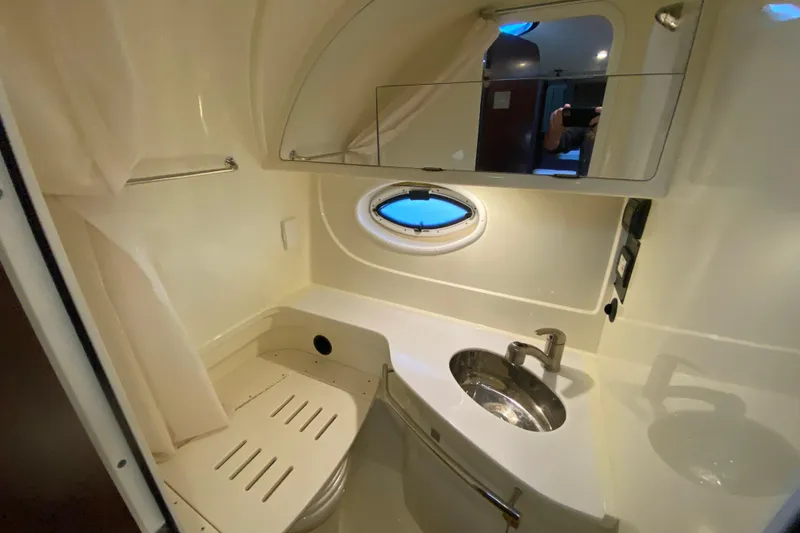 Slide: The Image of 2017 Monterey 355 Sport Yacht bathroom with sink, mirror, and porthole window. - 36