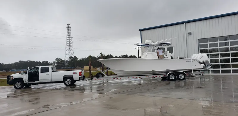 Slide: The Image of 2021 Onslow Bay 33TE boat on trailer with white truck. - 2