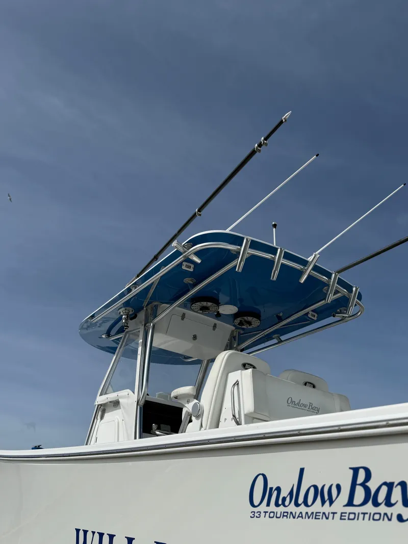 Slide: The Image of 2021 Onslow Bay 33TE boat with blue canopy and fishing rods. - 6