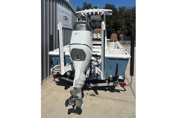 Slide: The Image of 2022 Sea Pro 248 Bay boat with powerful outboard motor, parked on a trailer. - 2