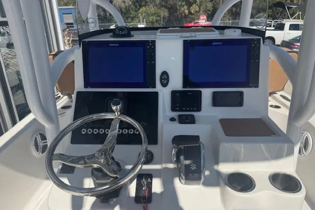 Slide: The Image of 2022 Sea Pro 248 Bay boat dashboard with dual screens and steering wheel. - 5