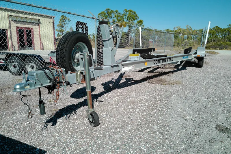 Slide: The Image of Trailer for 2016 Pathfinder 2200 T boat, parked on gravel near a chain-link fence. - 25