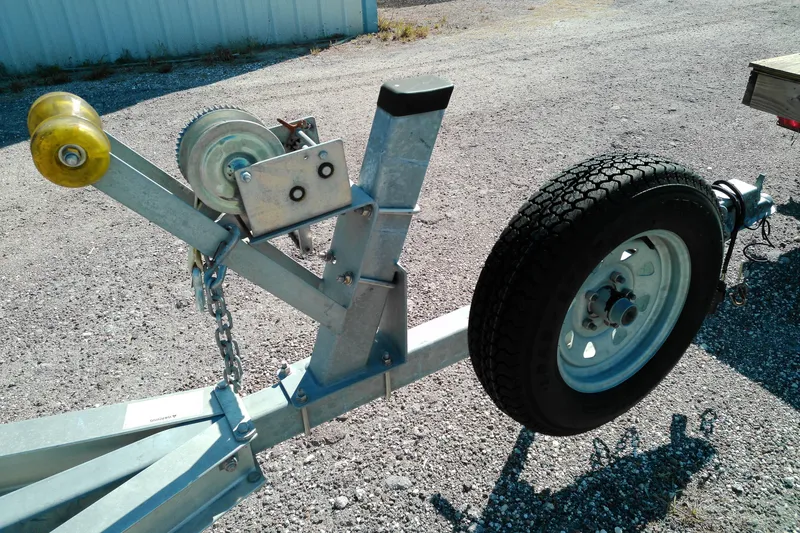 Slide: The Image of Trailer hitch and wheel assembly for 2016 Pathfinder 2200 T on gravel surface. - 29
