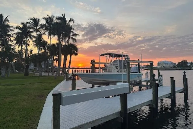 Slide: The Image of Sunset over marina with 2016 Pathfinder 2200 T boat docked, surrounded by palm trees. - 34
