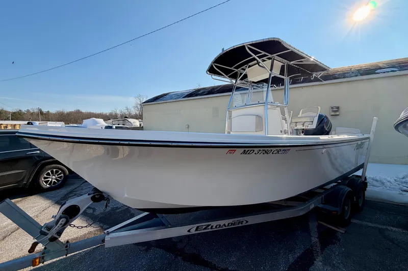 The Image of 2015 Parker 21SE Center Console boat on trailer, parked outdoors in sunlight. - 0