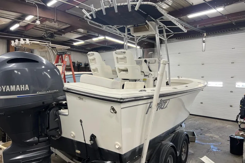 Slide: The Image of 2015 Parker 21SE Center Console boat on trailer, parked outdoors under clear blue sky. - 2