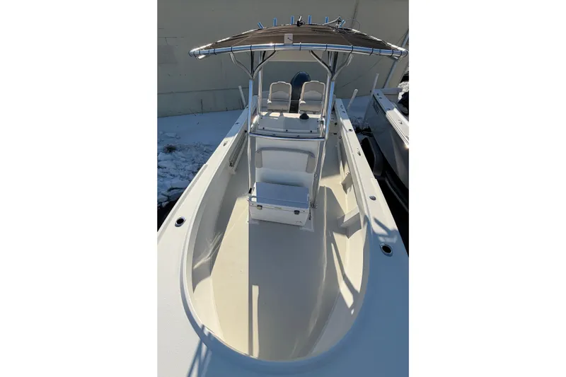 Slide: The Image of 2015 Parker 21SE Center Console boat with T-top and seating, docked in snowy surroundings. - 5
