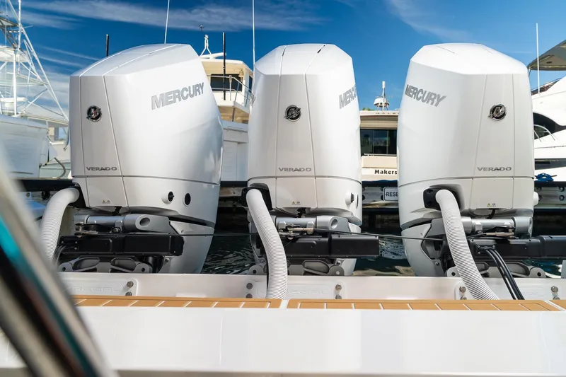 Slide: The Image of Triple Mercury Verado engines on a 2025 Regal 38 SAV boat, docked at a marina. - 2