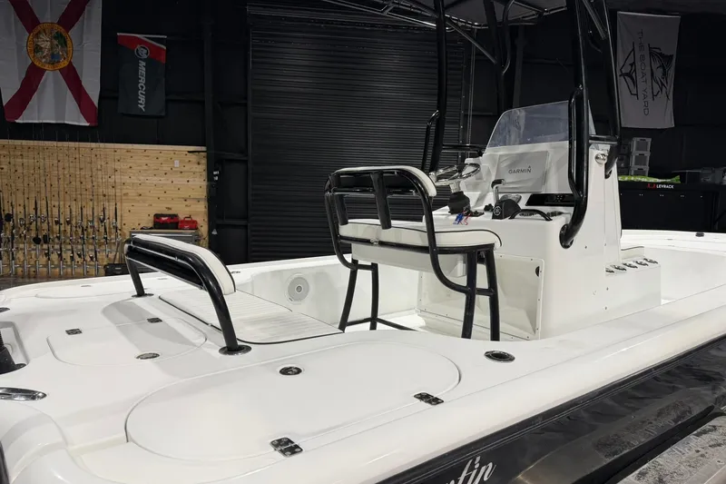 Slide: The Image of 2011 Yellowfin 24 Bay boat interior with fishing gear and console in a garage setting. - 12