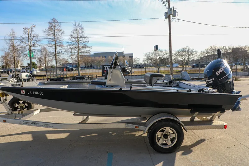 Slide: The Image of 2019 Express 18 boat on trailer with Evinrude motor, parked outdoors. - 10