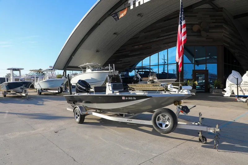 Slide: The Image of 2019 Express 18 boat on trailer outside dealership with American flag. - 4