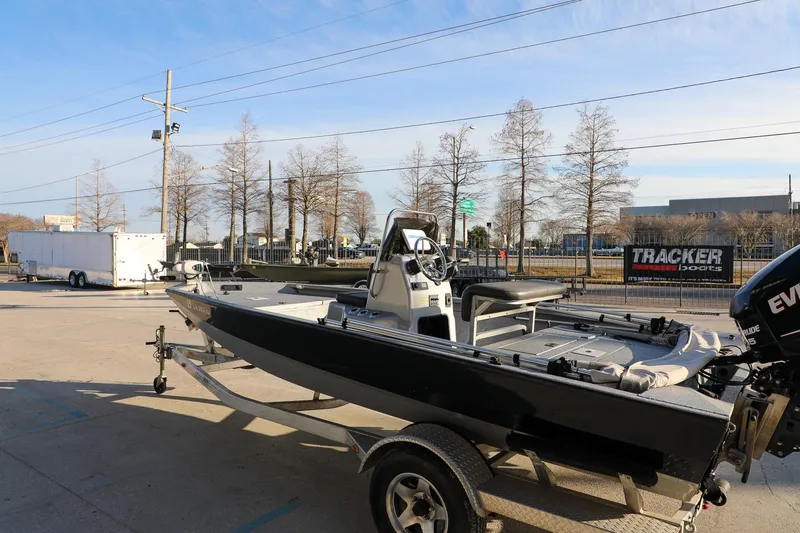 Slide: The Image of 2019 Express 18 boat on trailer, parked outdoors near trees and trailers. - 6