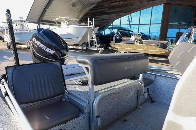 Slide: The Image of 2019 Express 18 boat interior with Evinrude motor, parked near other boats. - 9