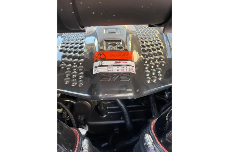 Slide: The Image of 2024 Tigé Ultré 23ZX engine close-up with Indmar label and warning sign. - 18