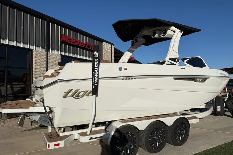 Slide: The Image of 2024 Tigé Ultré 23ZX boat on trailer outside dealership, showcasing sleek design and modern features. - 2