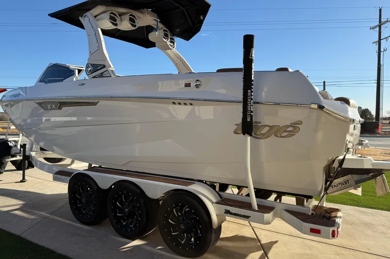 Slide: The Image of 2024 Tigé Ultré 23ZX boat on trailer, sleek design, white exterior, sunny day. - 4