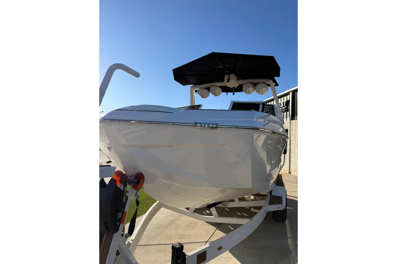 Slide: The Image of 2024 Tigé Ultré 23ZX boat on trailer under clear blue sky. - 6