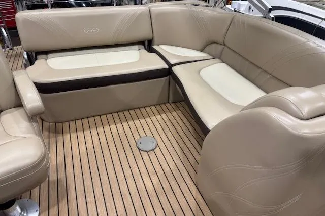 Slide: The Image of 2015 Harris Solstice 240 boat interior with beige seating and wood flooring. - 11