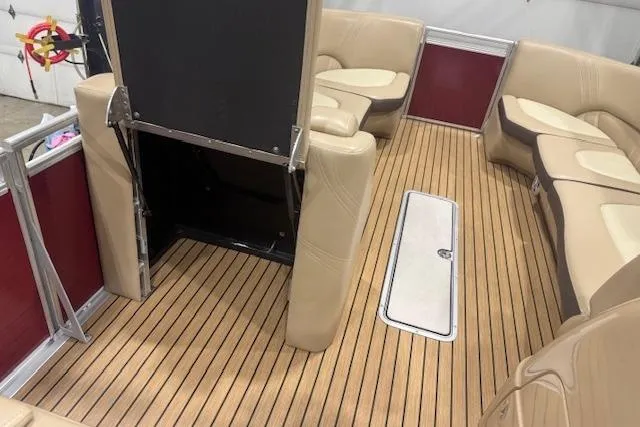 Slide: The Image of 2015 Harris Solstice 240 boat interior with beige seating and wood-style flooring. - 13