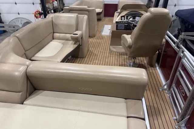 Slide: The Image of Interior of a 2015 Harris Solstice 240 pontoon boat with beige seating and wood flooring. - 14