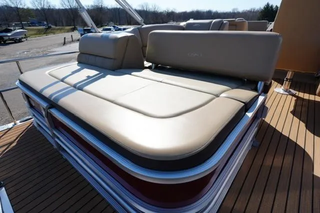 Slide: The Image of 2015 Harris Solstice 240 boat with beige seating and wooden deck. - 17