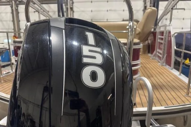 Slide: The Image of 2015 Harris Solstice 240 boat with a 150 HP engine, docked indoors. - 19