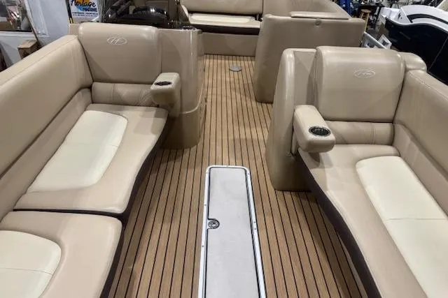 Slide: The Image of 2015 Harris Solstice 240 boat interior with beige seating and wood-style flooring. - 6