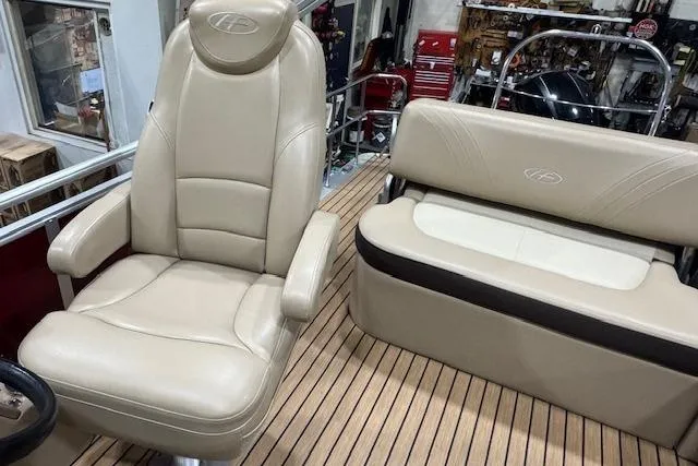 Slide: The Image of Luxurious seating on 2015 Harris Solstice 240 boat with beige upholstery and wood-style flooring. - 7