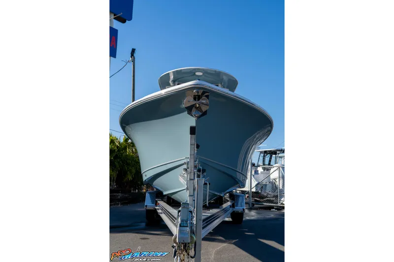 Slide: The Image of 2026 Sea Hunt Ultra 265 SE boat on trailer, viewed from the front under clear blue sky. - 10