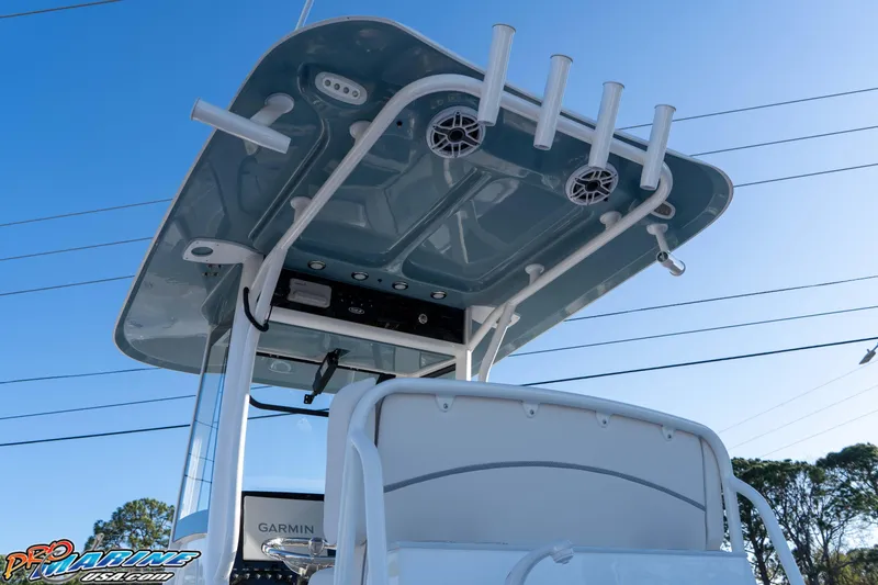 Slide: The Image of 2026 Sea Hunt Ultra 265 SE boat with T-top and rod holders against blue sky. - 12