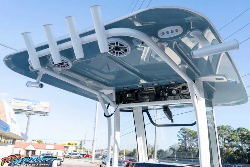 Slide: The Image of 2026 Sea Hunt Ultra 265 SE boat with T-top and rod holders, displayed outdoors. - 21