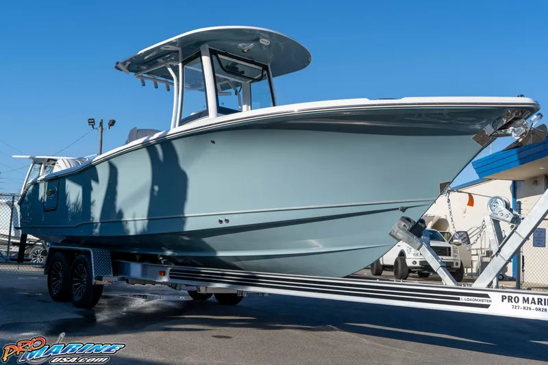 Slide: The Image of 2026 Sea Hunt Ultra 265 SE boat on trailer, displayed outdoors under clear blue sky. - 8