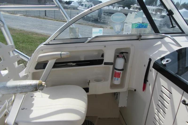Slide: The Image of 2004 Grady-White Seafarer 228 boat interior with steering wheel and fire extinguisher. - 24