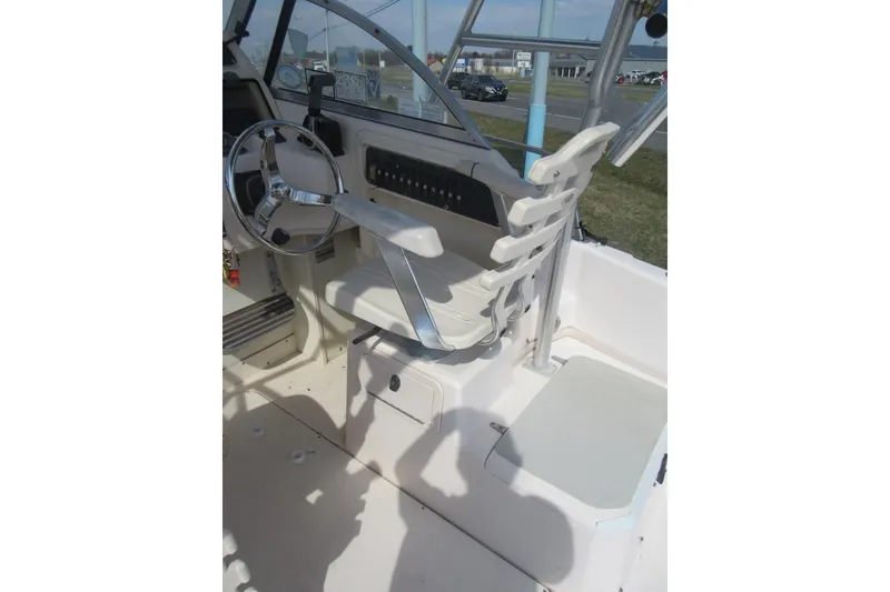 Slide: The Image of 2004 Grady-White Seafarer 228 boat cockpit with steering wheel and seating. - 26