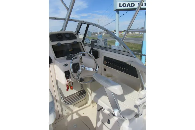 Slide: The Image of 2004 Grady-White Seafarer 228 boat cockpit with steering wheel and control panel. - 27