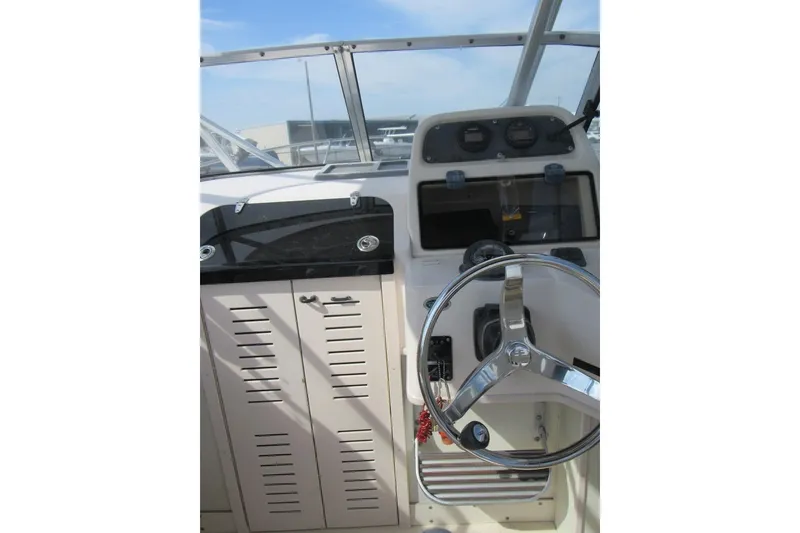 Slide: The Image of 2004 Grady-White Seafarer 228 boat helm with steering wheel and instrument panel. - 29