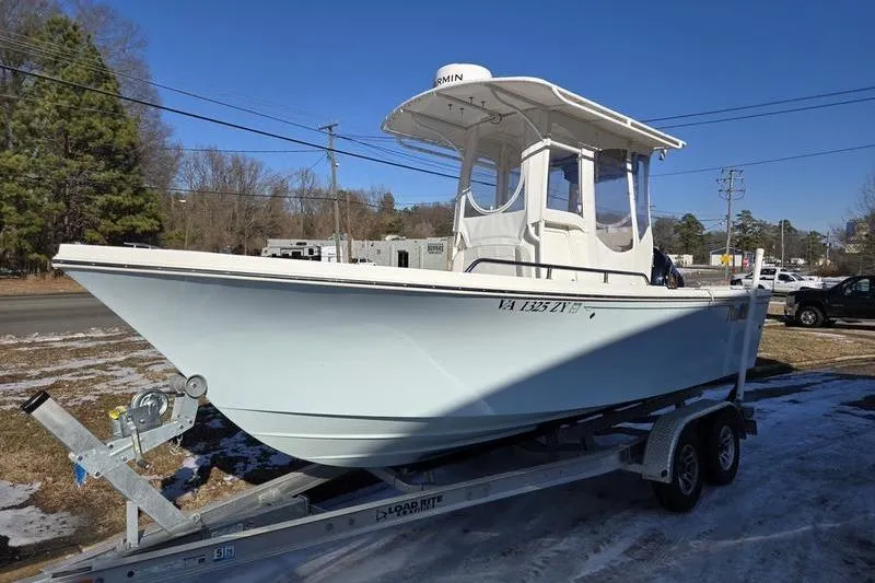 The Image of 2021 Parker 2100 CC boat on trailer, parked outdoors under clear blue sky. - 0