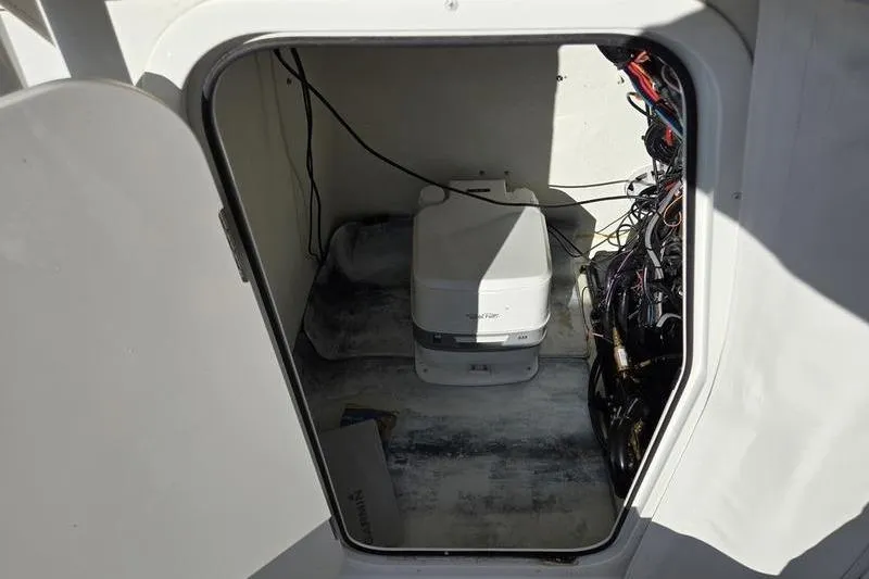 Slide: The Image of Storage compartment in a 2021 Parker 2100 CC boat, featuring wiring and equipment. - 10