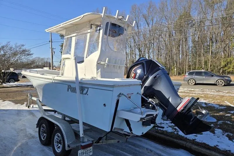 Slide: The Image of 2021 Parker 2100 CC boat on trailer with outboard motor, parked on snowy roadside. - 6