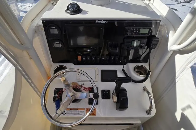Slide: The Image of Control panel of a 2021 Parker 2100 CC boat with steering wheel and navigation instruments. - 8