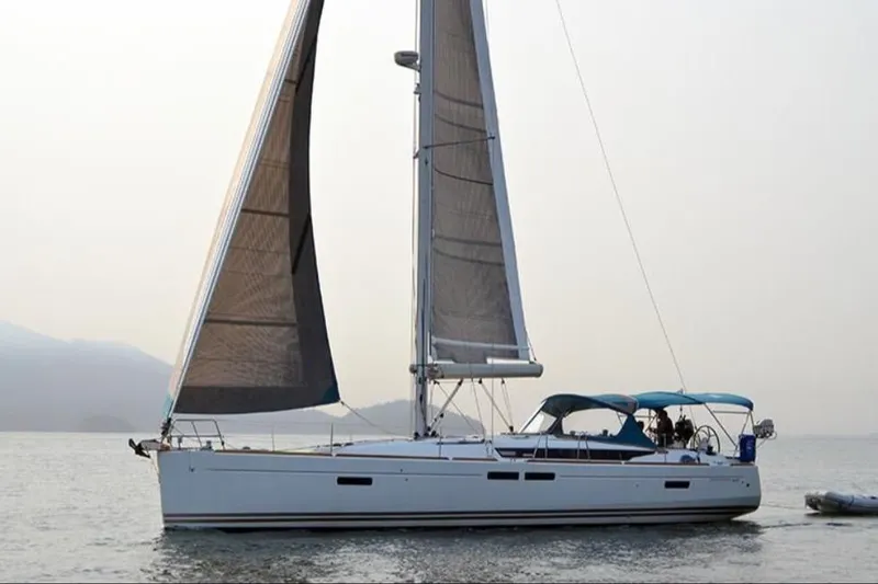 The Image of 2014 Jeanneau Sun Odyssey 469 sailboat on calm water, featuring sleek design and spacious deck. - 0