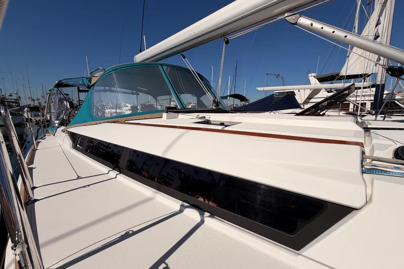 Slide: The Image of 2014 Jeanneau Sun Odyssey 469 sailboat docked, featuring sleek design and blue canopy. - 11
