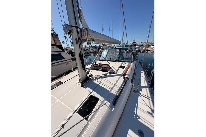 Slide: The Image of 2014 Jeanneau Sun Odyssey 469 sailboat docked in a marina under clear blue skies. - 23