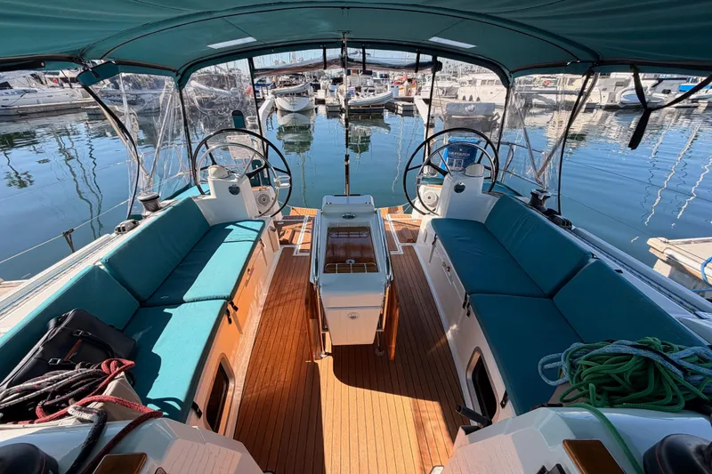 Slide: The Image of 2014 Jeanneau Sun Odyssey 469 sailboat cockpit with dual steering wheels and teal seating. - 27