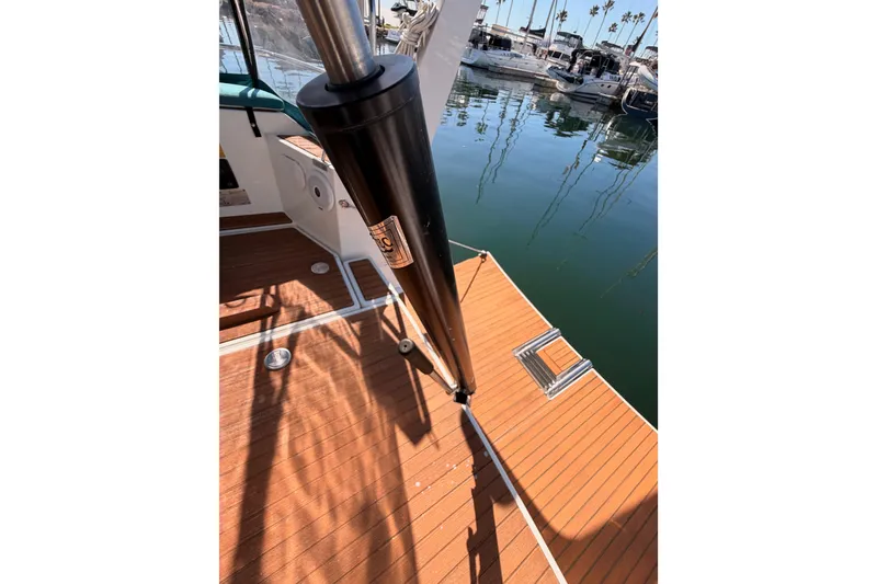 Slide: The Image of 2014 Jeanneau Sun Odyssey 469 deck with polished wood finish and marina view. - 31
