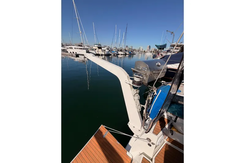 Slide: The Image of 2014 Jeanneau Sun Odyssey 469 docked at a marina, clear blue sky, calm water. - 33